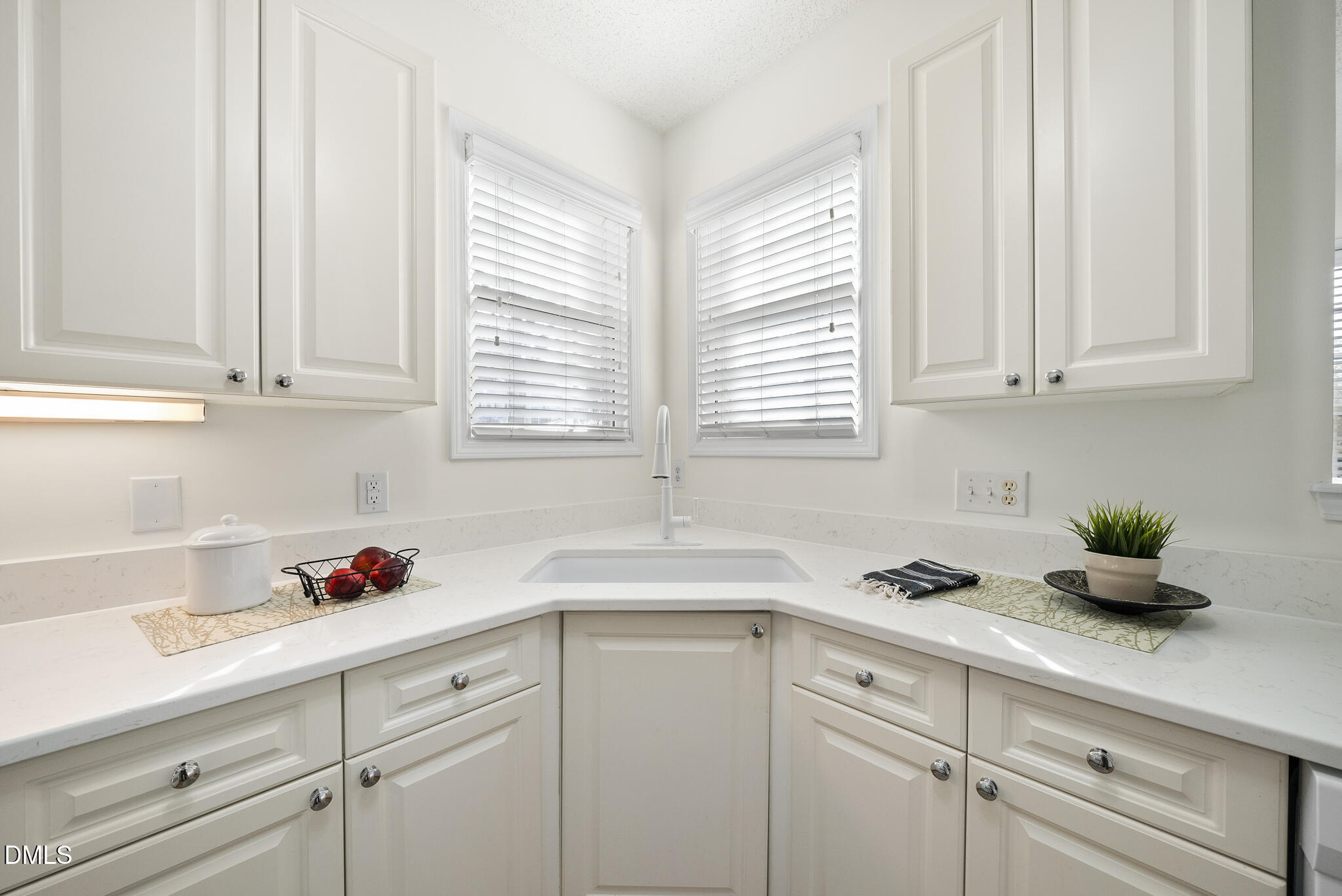 7710 Astoria Place Raleigh, NC 27612 - Photo 12 of 34 a kitchen with white cabinets and a window