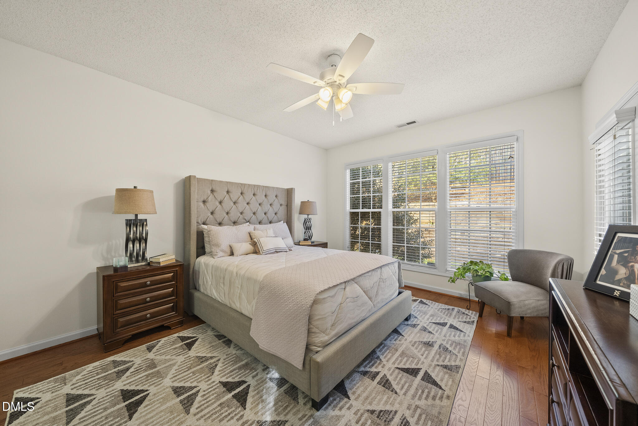 7710 Astoria Place Raleigh, NC 27612 - Photo 15 of 34 a bedroom with a large bed and a chandelier