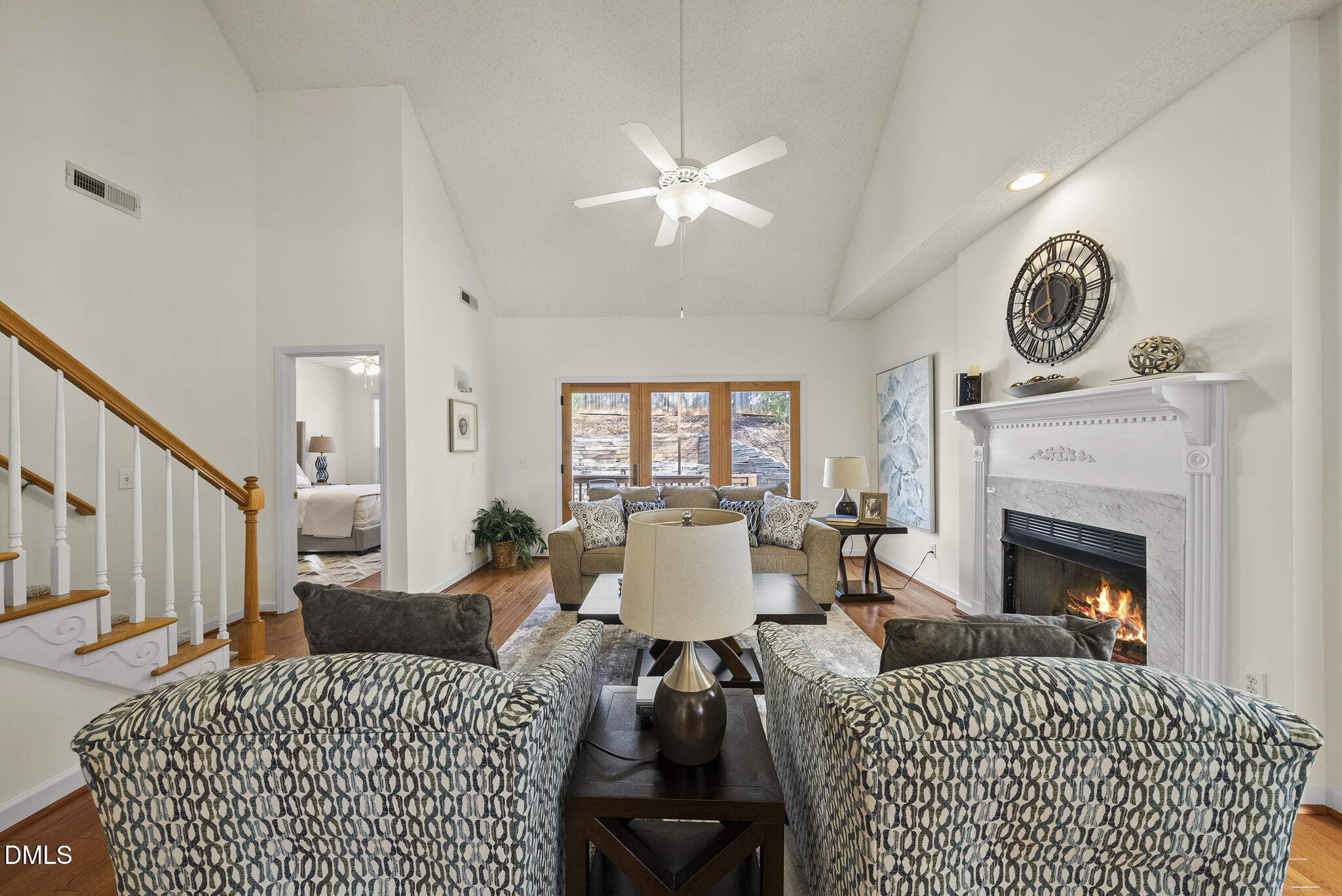 7710 Astoria Place Raleigh, NC 27612 - Photo 3 of 34 a living room with furniture a clock and a fireplace