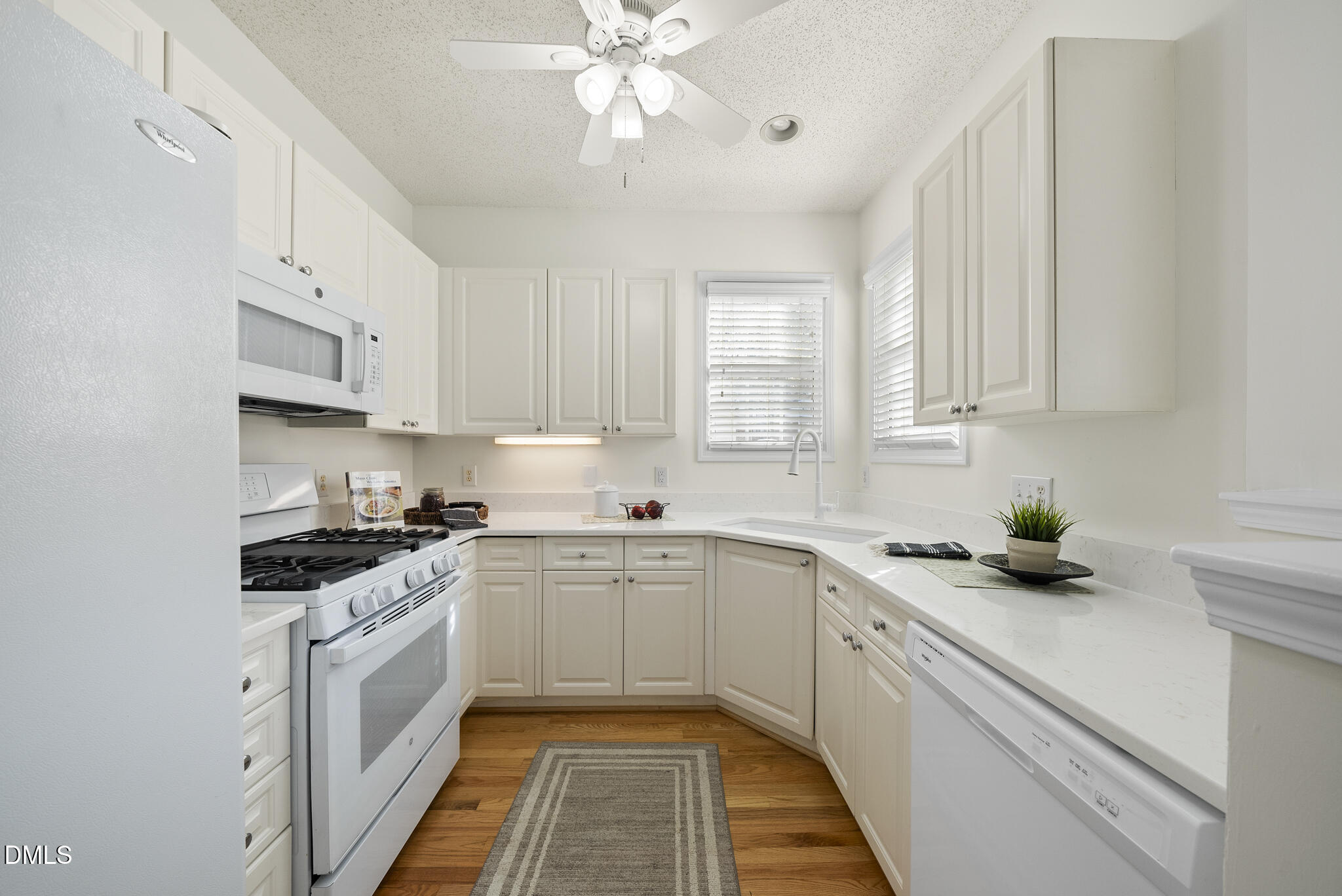 7710 Astoria Place Raleigh, NC 27612 - Photo 9 of 34 a kitchen with a white cabinets and white appliances