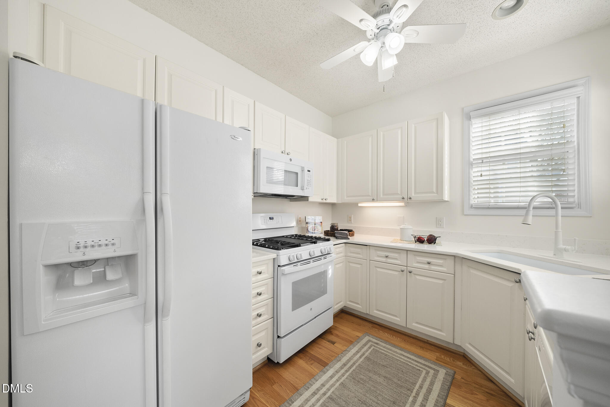 7710 Astoria Place Raleigh, NC 27612 - Photo 10 of 34 a kitchen with a sink cabinets stainless steel appliances and a window