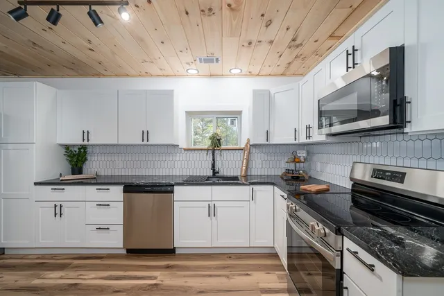 a kitchen with a sink stove and microwave