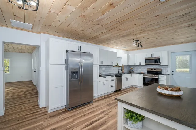 a kitchen with refrigerator and white cabinets