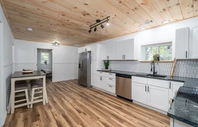 a kitchen with stainless steel appliances granite countertop a sink stove and refrigerator