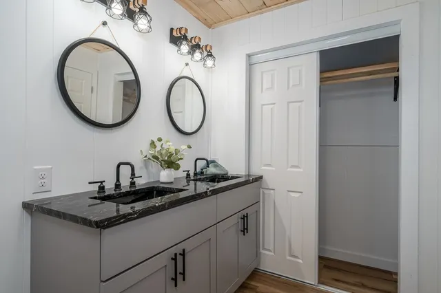 a bathroom with a granite countertop sink and a mirror