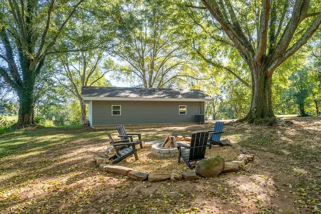 a view of a chairs and table in the back yard of the house