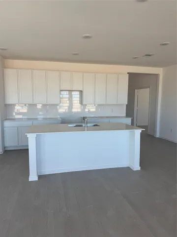 a kitchen with granite countertop white cabinets and a sink