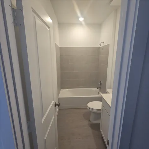 a bathroom with a granite countertop toilet a sink and a bathtub