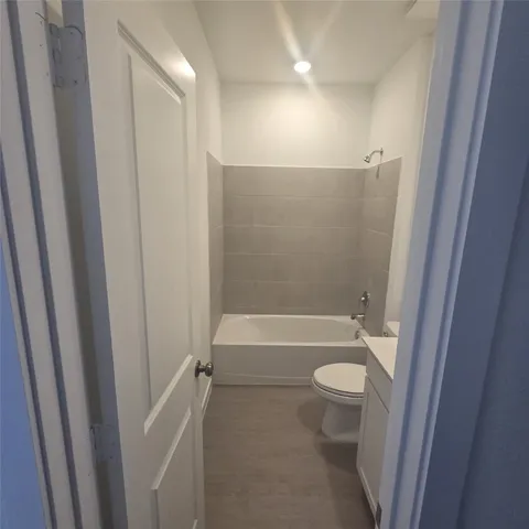a bathroom with a granite countertop bathtub shower and toilet