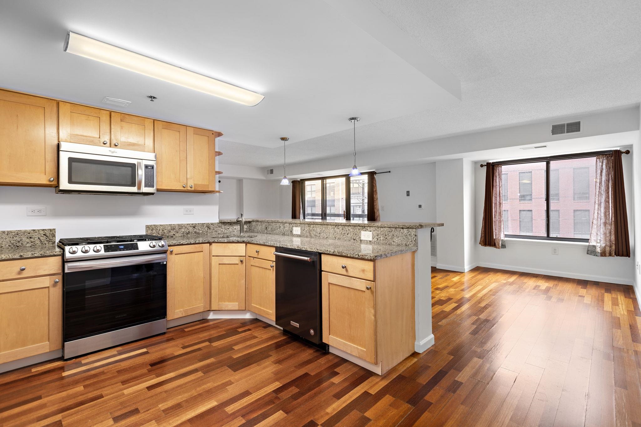 700 1st Street, Unit 3E Hoboken, NJ 07030 - Photo 4 of 16 a kitchen with stainless steel appliances granite countertop a stove a sink and a microwave