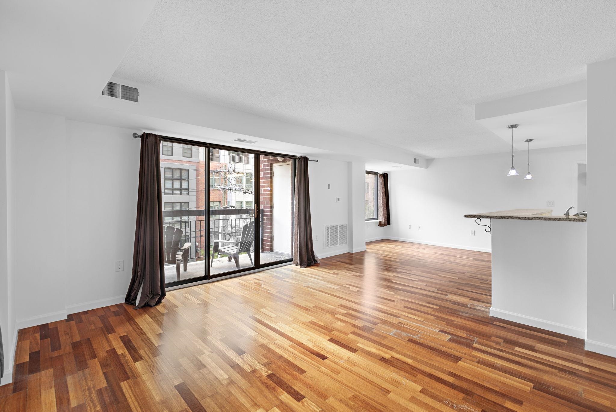 700 1st Street, Unit 3E Hoboken, NJ 07030 - Photo 7 of 16 a view of an empty room with wooden floor and a window