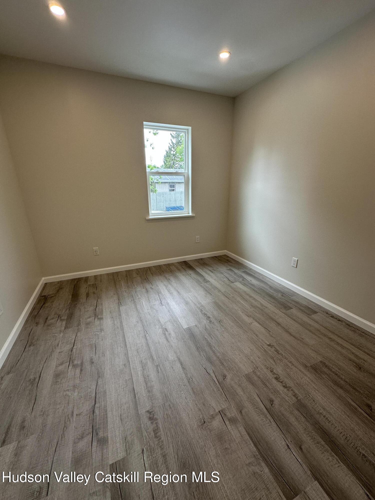 61 Thompson Street, Unit 4 Catskill, NY 12414 - Photo 6 of 7 an empty room with wooden floor and windows