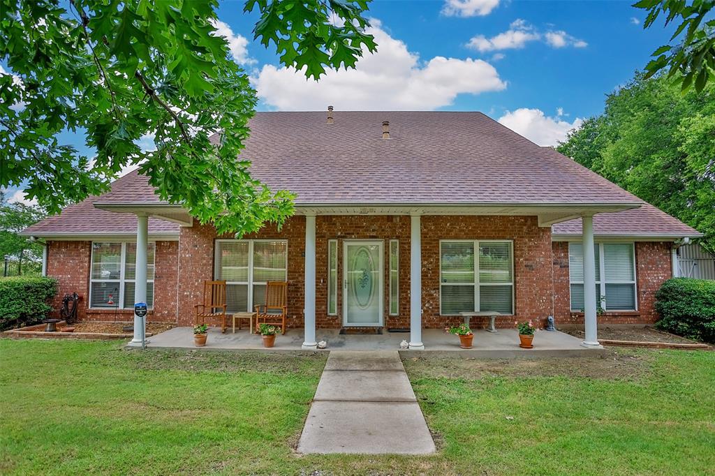 8770 Rector Road Sanger, TX 76266 - Photo 1 of 1 a front view of a house with a garden and porch