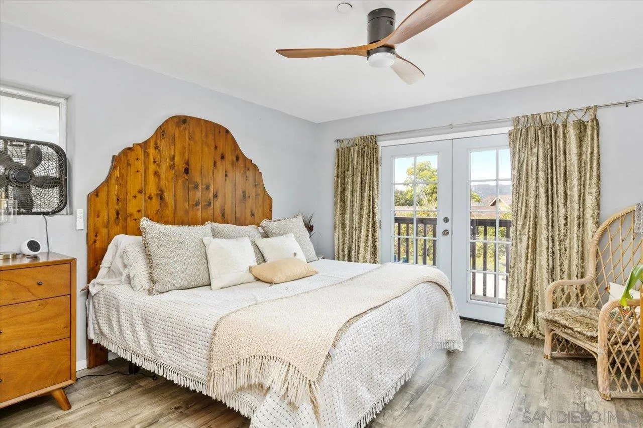 1379 Sunny Heights Road Fallbrook, CA 92028 - Photo 39 of 64 a bedroom with a large bed and a chandelier