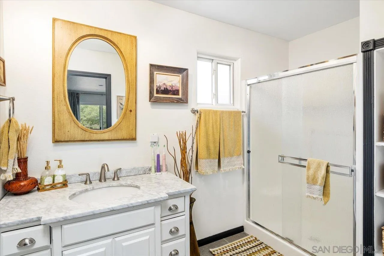 1379 Sunny Heights Road Fallbrook, CA 92028 - Photo 44 of 64 a bathroom with a granite countertop sink a mirror and a shower
