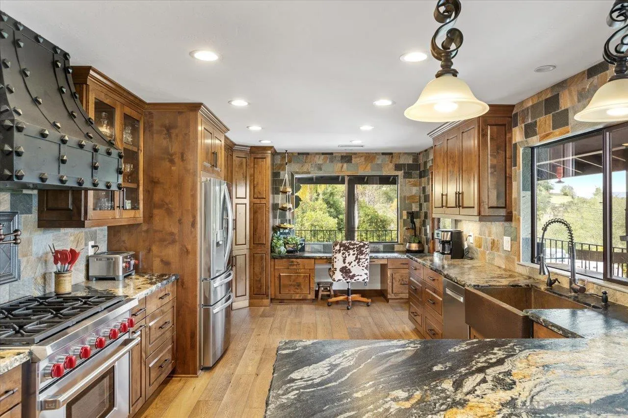 1379 Sunny Heights Road Fallbrook, CA 92028 - Photo 9 of 64 a large kitchen with stainless steel appliances granite countertop a stove a sink dishwasher a dining table and chairs with wooden floor