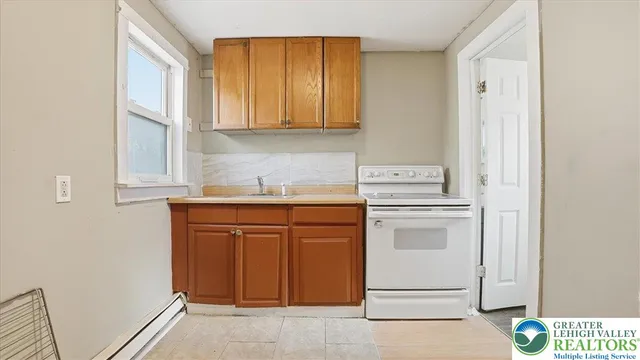 a kitchen with a sink a stove and cabinets