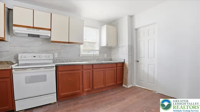 a kitchen with granite countertop white cabinets and white appliances