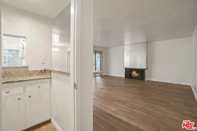 a view of a livingroom with wooden floor and a fireplace