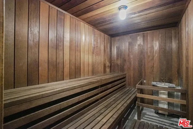 a large kitchen with granite countertop a sink and white cabinets
