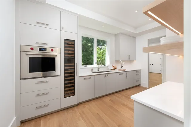 a kitchen with stainless steel appliances white cabinets and a wooden floor