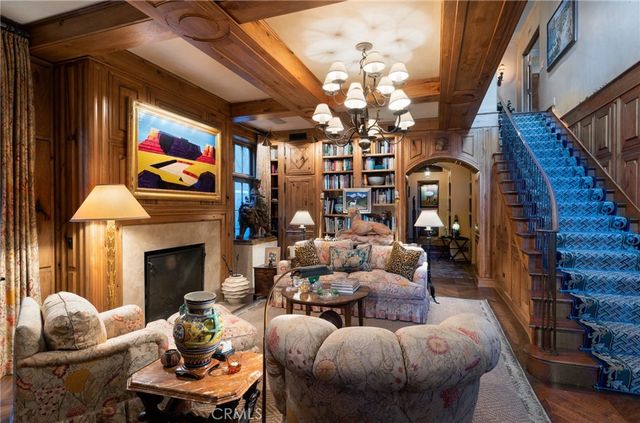 a living room with furniture a chandelier and a fireplace