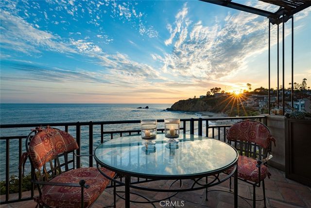 a view of a street with potted plants and large trees