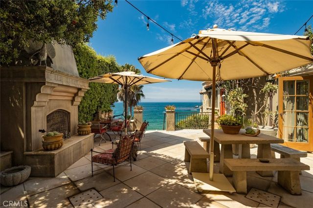 a patio with tables and chairs under an umbrella