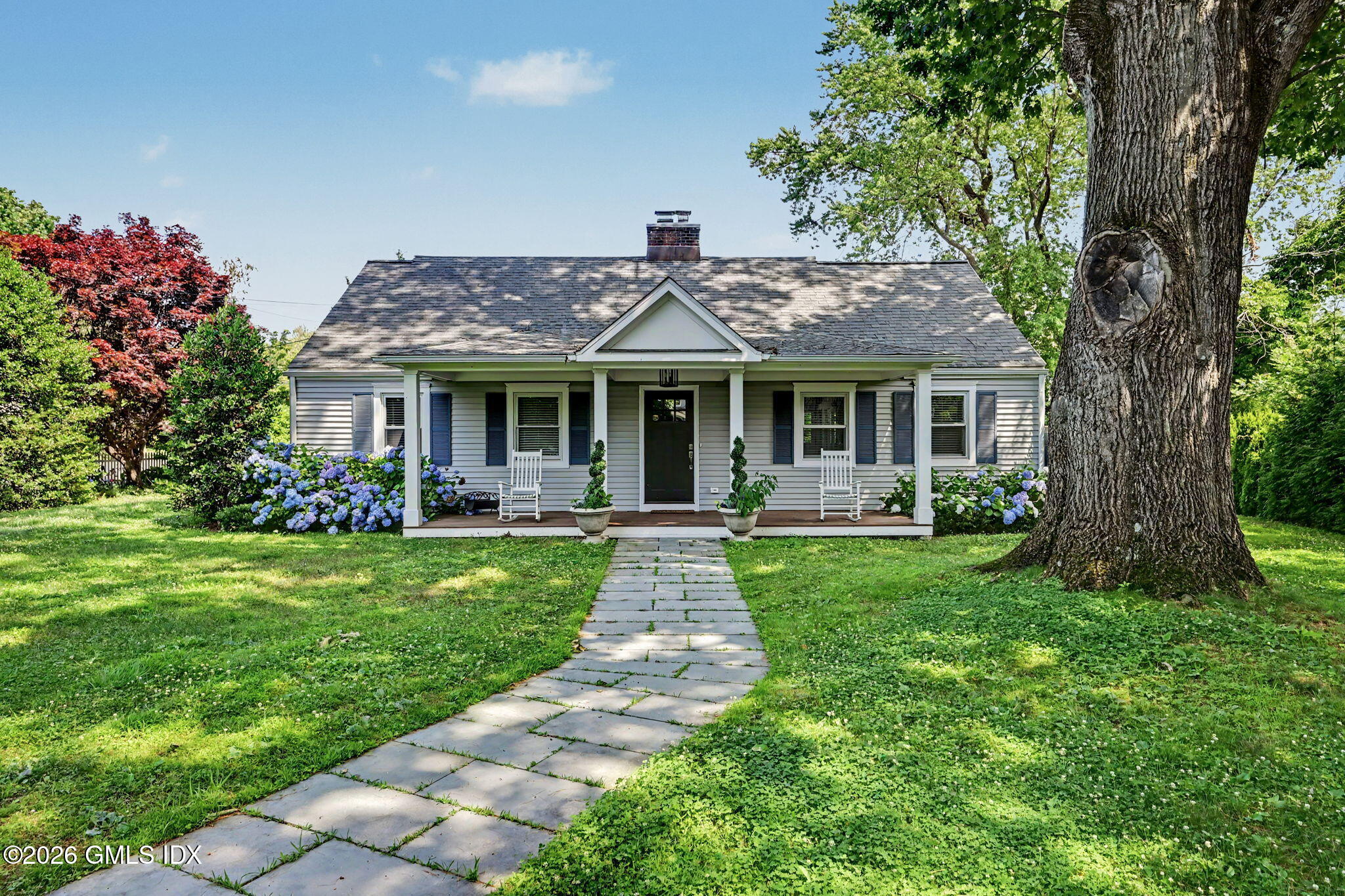 124 Shore Road Old Greenwich, CT 06870 - Photo 3 of 28 a front view of a house with garden