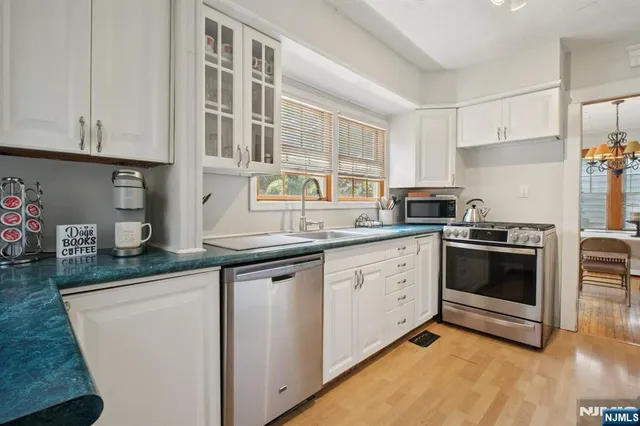 a kitchen with granite countertop white cabinets and white appliances
