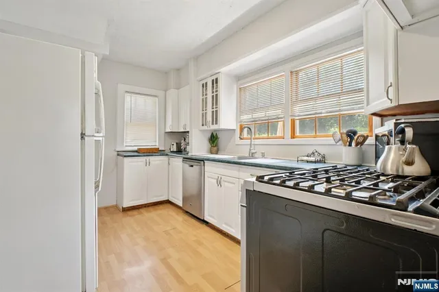 a kitchen with white cabinets and appliances
