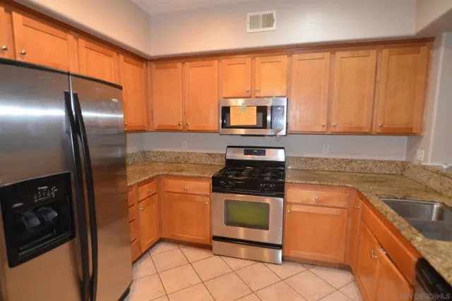 a kitchen with stainless steel appliances granite countertop a stove a sink and a microwave