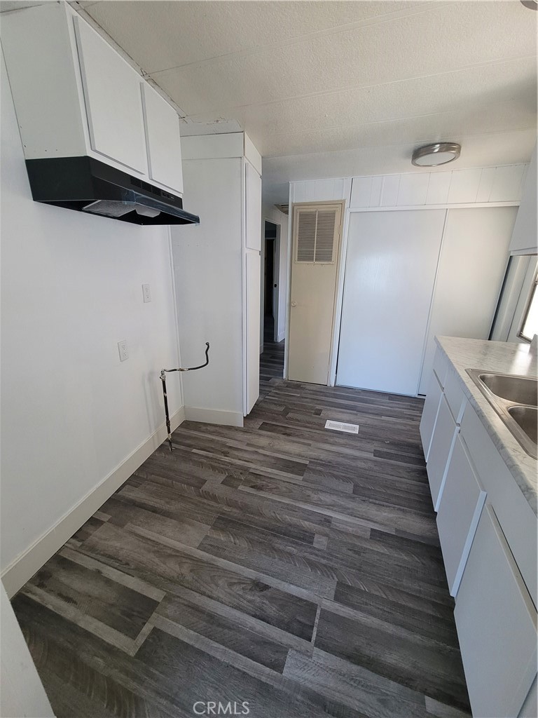 18151 Valley Boulevard, Unit 55 La Puente, CA 91744 - Photo 19 of 38 a view of a hallway with wooden floor and cabinets