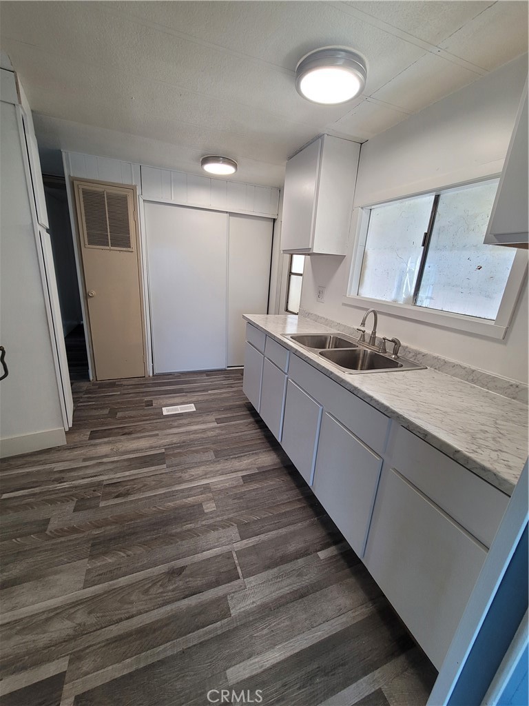 18151 Valley Boulevard, Unit 55 La Puente, CA 91744 - Photo 22 of 38 a large kitchen with a sink and dishwasher a stove top oven with wooden floor