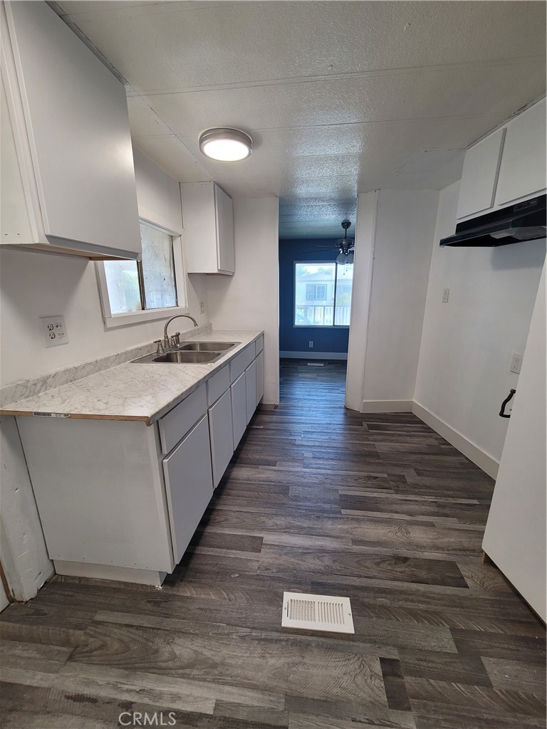 18151 Valley Boulevard, Unit 55 La Puente, CA 91744 - Photo 24 of 38 a kitchen with sink cabinets and wooden floor
