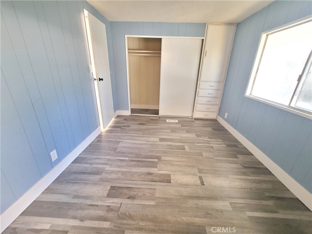 18151 Valley Boulevard, Unit 55 La Puente, CA 91744 - Photo 30 of 38 a view of an empty room with wooden floor and a window