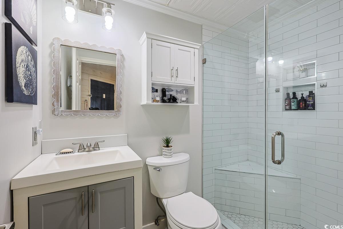 1100 Possum Trot Road, Unit G324 North Myrtle Beach, SC 29582 - Photo 20 of 28 Bathroom with a shower stall, vanity, and crown molding