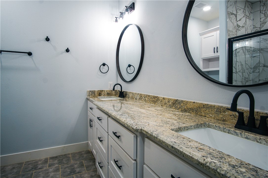 1614 Louis Street Bryan, TX 77803 - Photo 10 of 29 Bathroom featuring double vanity and a shower with shower door