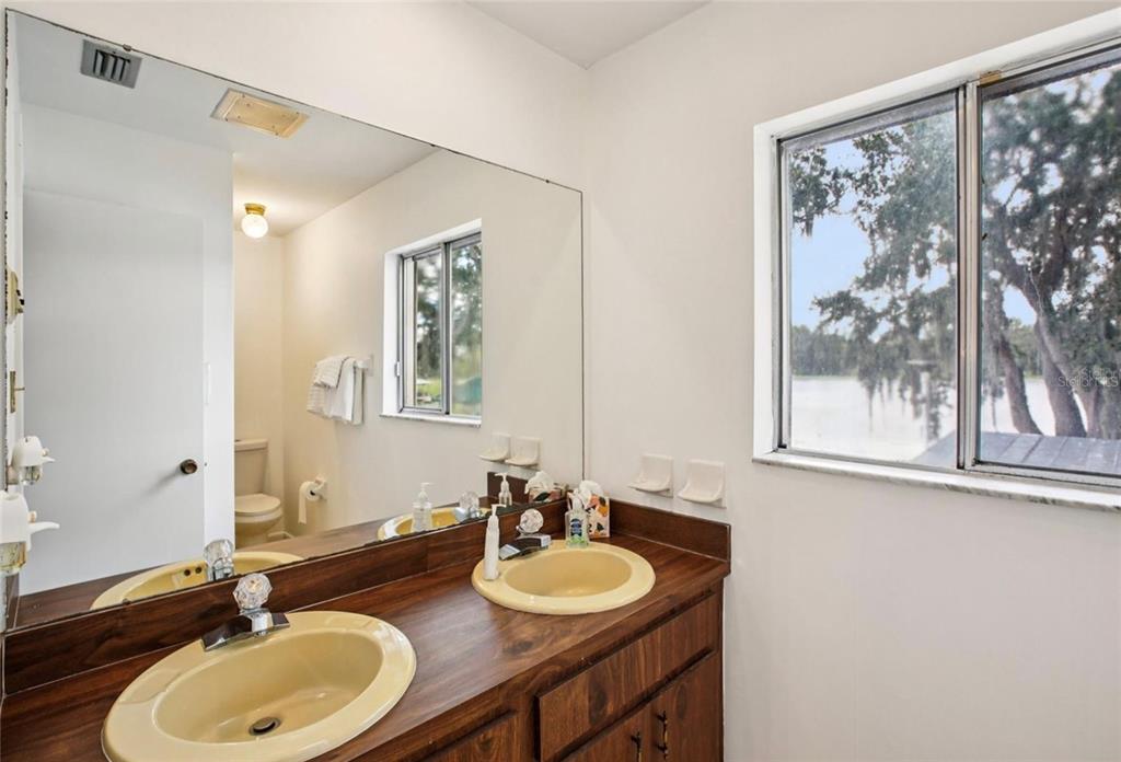 19254 Blount Road Lutz, FL 33558 - Photo 27 of 34 a bathroom with a double vanity sink and a mirror