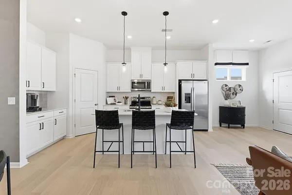 a kitchen with stainless steel appliances kitchen island granite countertop a stove a sink and a refrigerator