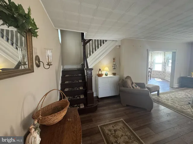 a dining room with furniture wooden floor a rug and a chandelier