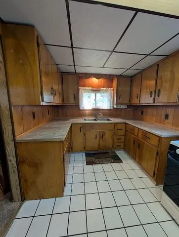 a kitchen with a sink a stove top oven and cabinets