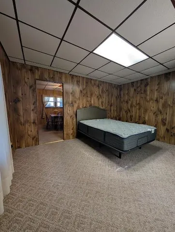 a bedroom with a bed a chandelier and a window