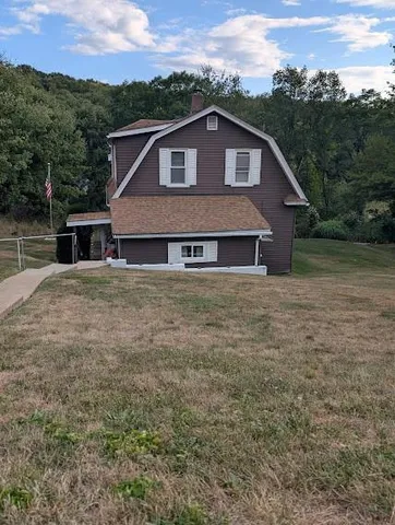 a view of a house with a yard and a wooden fence