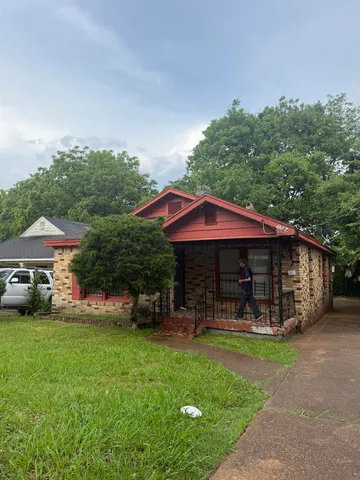 a view of a house with a yard patio and fire pit