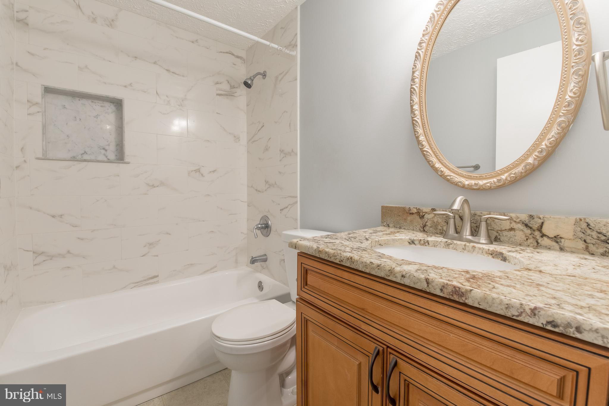 8334 Windfall Road Springfield, VA 22153 - Photo 16 of 16 a bathroom with a granite countertop sink mirror vanity and toilet