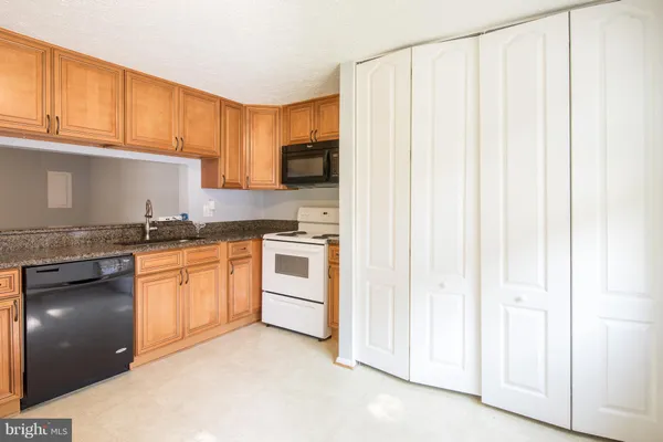 a kitchen with granite countertop white cabinets and stainless steel appliances