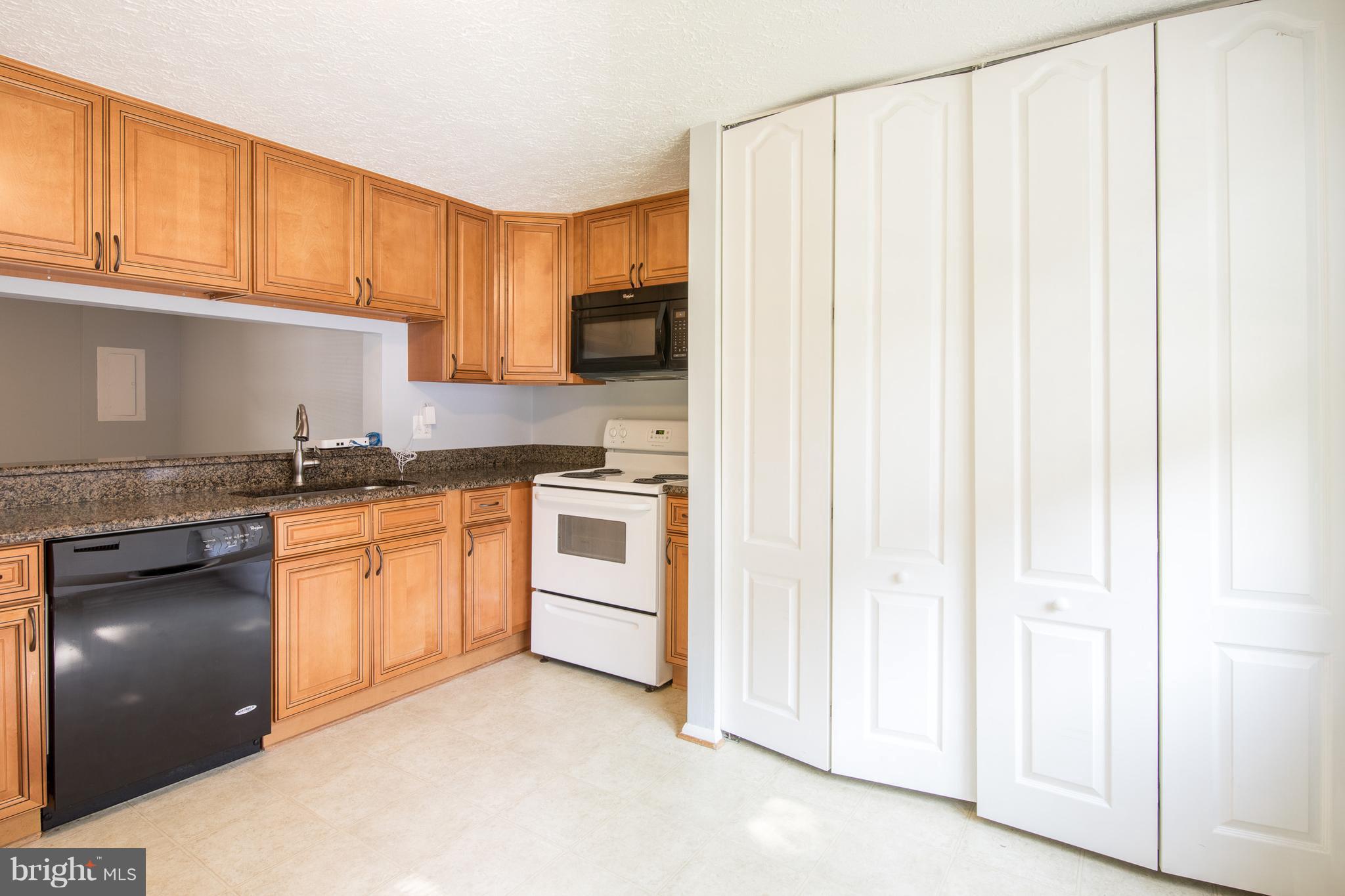 8334 Windfall Road Springfield, VA 22153 - Photo 5 of 16 a kitchen with granite countertop white cabinets and stainless steel appliances
