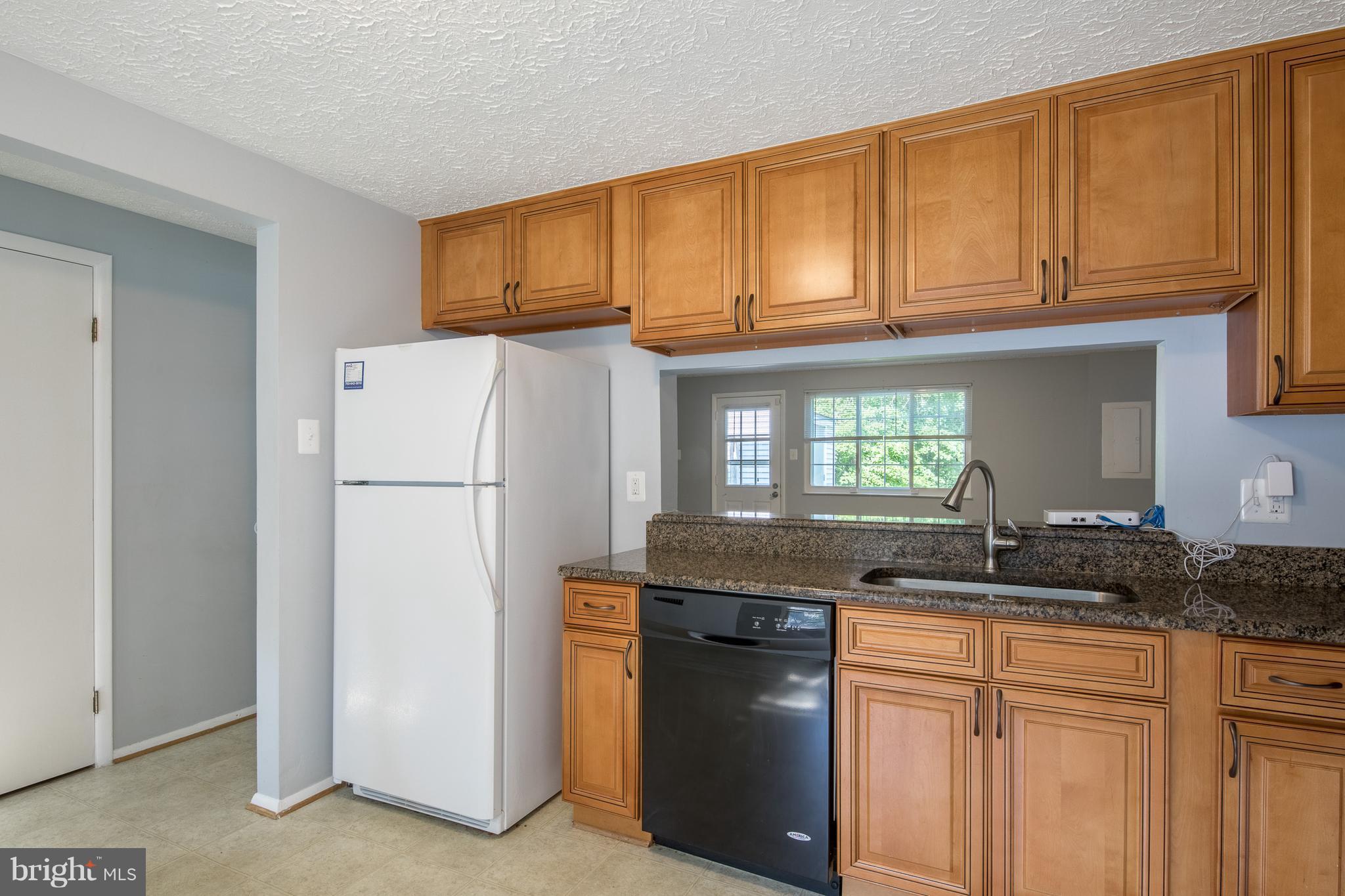 8334 Windfall Road Springfield, VA 22153 - Photo 7 of 16 a kitchen with granite countertop a refrigerator a sink and a stove