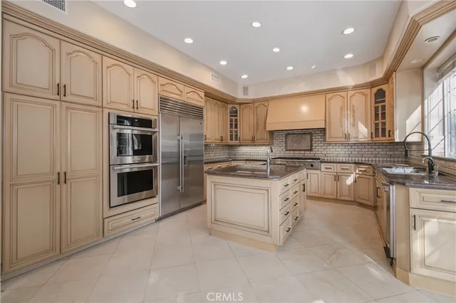 a kitchen with granite countertop white cabinets and stainless steel appliances
